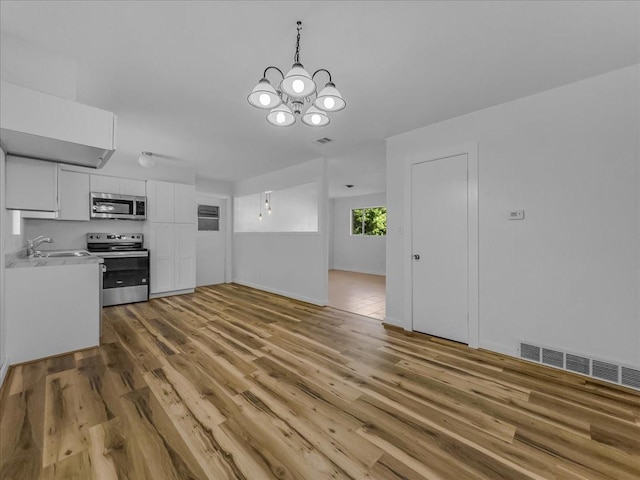 202 E Rentz St, Weatherford, TX 76086 - unfurnished living room with a chandelier and light wood-style floors