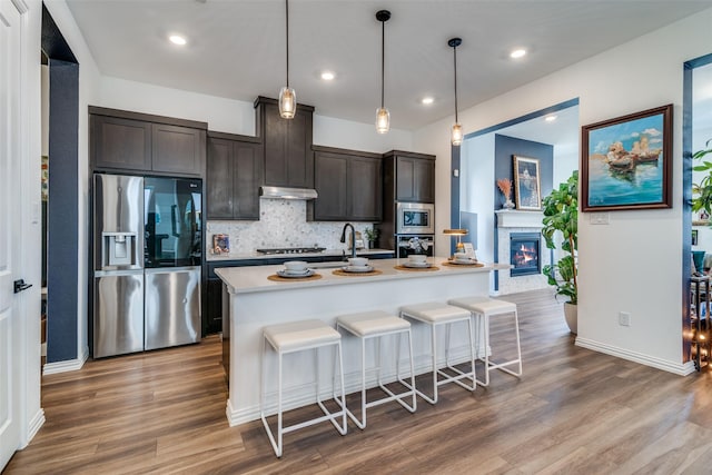 5511 Grand Ave, Sachse, TX 75048 - kitchen featuring appliances with stainless steel finishes, wood finished floors, tasteful backsplash, light countertops, and recessed lighting
