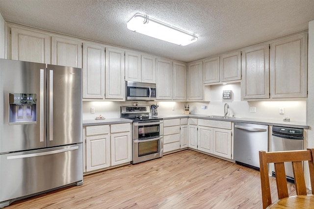 321 E Hampton Rd, Crowley, TX 76036 - kitchen featuring appliances with stainless steel finishes, light wood finished floors, light countertops, and a textured ceiling