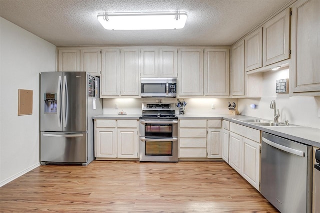 321 E Hampton Rd, Crowley, TX 76036 - kitchen with stainless steel appliances, light wood-type flooring, light countertops, and a textured ceiling