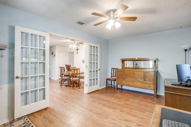321 E Hampton Rd, Crowley, TX 76036 - sitting room with french doors, light wood-style floors, ceiling fan, and a textured ceiling