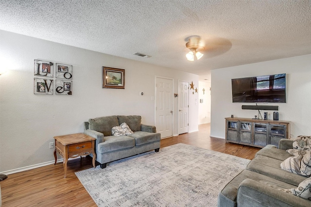 321 E Hampton Rd, Crowley, TX 76036 - living area with wood finished floors, a ceiling fan, and a textured ceiling