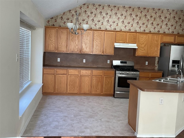 939 Clear Creek Dr, Mesquite, TX 75181 - kitchen with appliances with stainless steel finishes, under cabinet range hood, lofted ceiling, a chandelier, and dark countertops