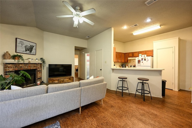 1113-1115 Bayfield Dr, Denton, TX 76209 - living room with wood finished floors, ceiling fan, vaulted ceiling, a fireplace, and a textured ceiling