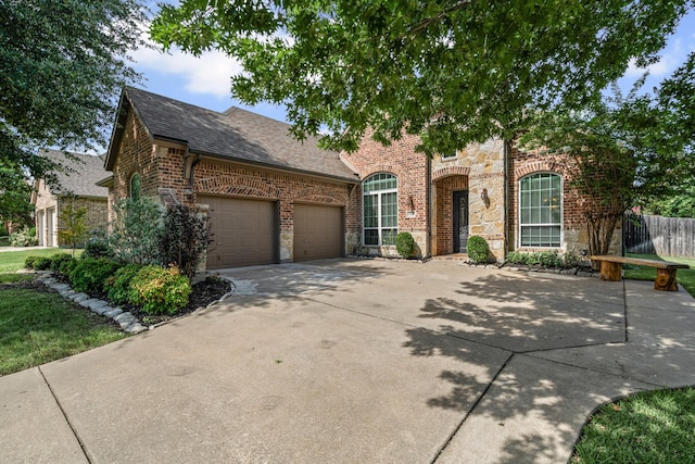1904 Yarmouth Ct, Mansfield, TX 76063 - view of front of house with stone siding, roof with shingles, an attached garage, brick siding, and driveway