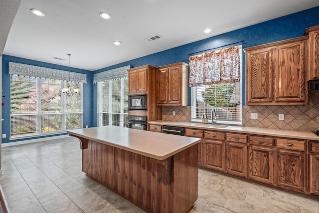 1904 Yarmouth Ct, Mansfield, TX 76063 - kitchen with black appliances, a chandelier, light countertops, a kitchen island, and decorative backsplash