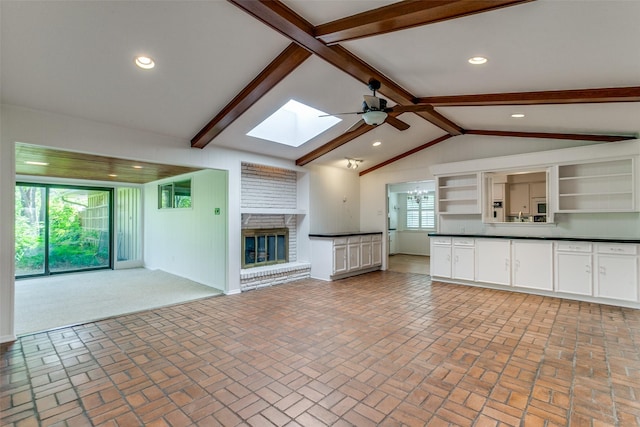 4818 Thunder Rd, Dallas, TX 75244 - unfurnished living room featuring ceiling fan, a skylight, a fireplace, brick patterned flooring, and recessed lighting