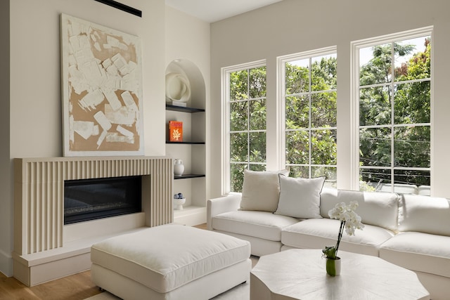 3939 Hawthorne Unit 103, Dallas, TX 75219 - living room with wood finished floors, healthy amount of natural light, built in shelves, and a glass covered fireplace