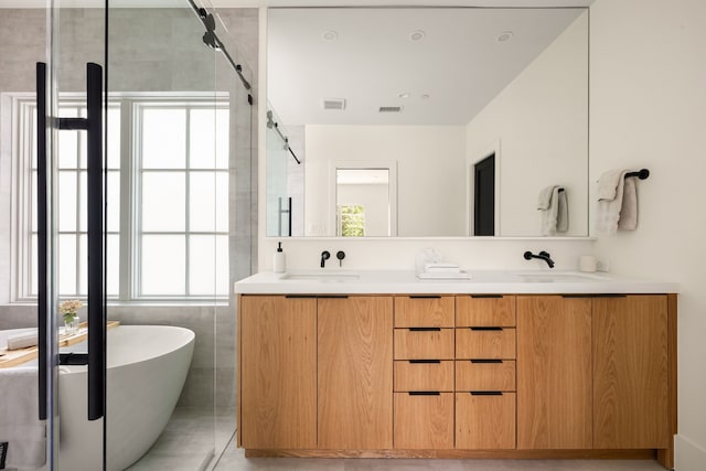 3939 Hawthorne Unit 103, Dallas, TX 75219 - bathroom featuring a freestanding tub, double vanity, a shower stall, and tile patterned floors