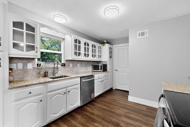 1521 Windsor Dr, Glenn Heights, TX 75154 - kitchen featuring appliances with stainless steel finishes, tasteful backsplash, a textured ceiling, glass insert cabinets, and white cabinets