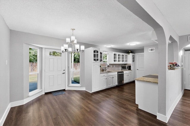 1521 Windsor Dr, Glenn Heights, TX 75154 - kitchen with stainless steel appliances, white cabinetry, dark wood-style flooring, a chandelier, and a textured ceiling