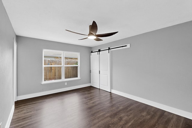 1521 Windsor Dr, Glenn Heights, TX 75154 - unfurnished bedroom featuring a barn door, dark wood finished floors, and a ceiling fan