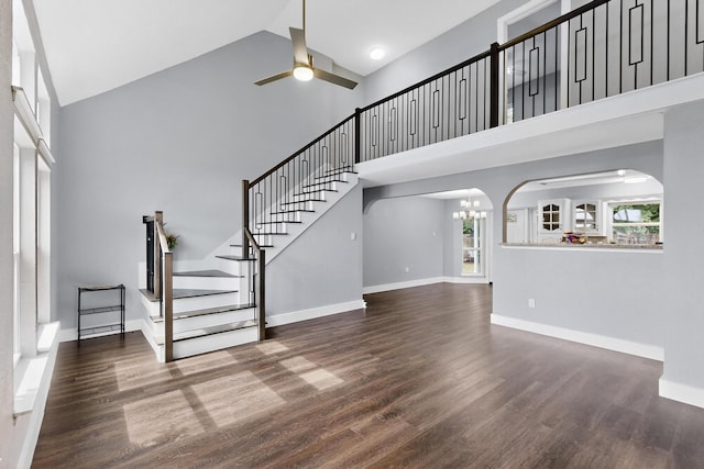 1521 Windsor Dr, Glenn Heights, TX 75154 - unfurnished living room featuring high vaulted ceiling, arched walkways, wood finished floors, stairway, and a ceiling fan