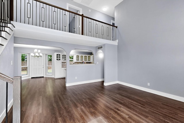 1521 Windsor Dr, Glenn Heights, TX 75154 - unfurnished living room with a chandelier, wood finished floors, a high ceiling, stairway, and arched walkways