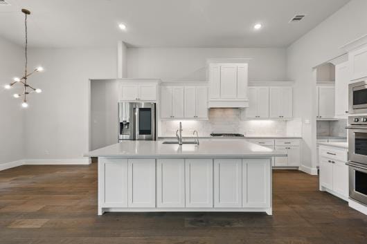 521 Winslow Ln, Prosper, TX 75078 - kitchen featuring appliances with stainless steel finishes, an island with sink, white cabinetry, light countertops, and recessed lighting