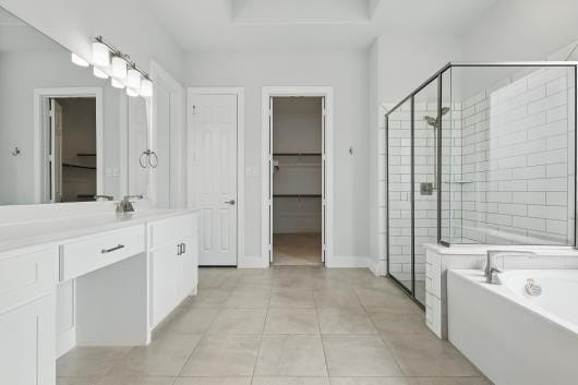 521 Winslow Ln, Prosper, TX 75078 - full bath featuring vanity, a shower stall, a bath, tile patterned flooring, and a spacious closet