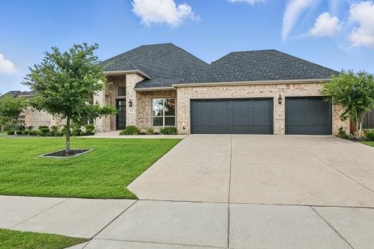 521 Winslow Ln, Prosper, TX 75078 - view of front facade with an attached garage, driveway, a front lawn, brick siding, and a shingled roof