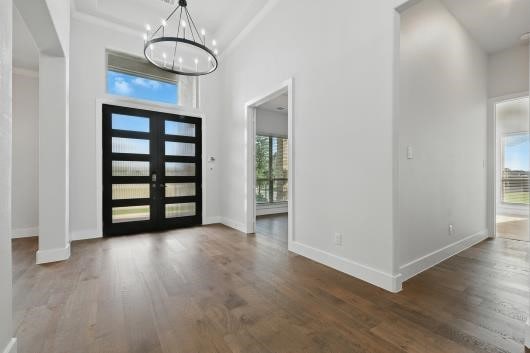521 Winslow Ln, Prosper, TX 75078 - entryway with a chandelier, wood finished floors, a high ceiling, and french doors