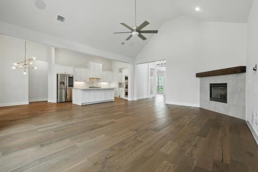 521 Winslow Ln, Prosper, TX 75078 - unfurnished living room with high vaulted ceiling, a ceiling fan, a fireplace, and wood finished floors