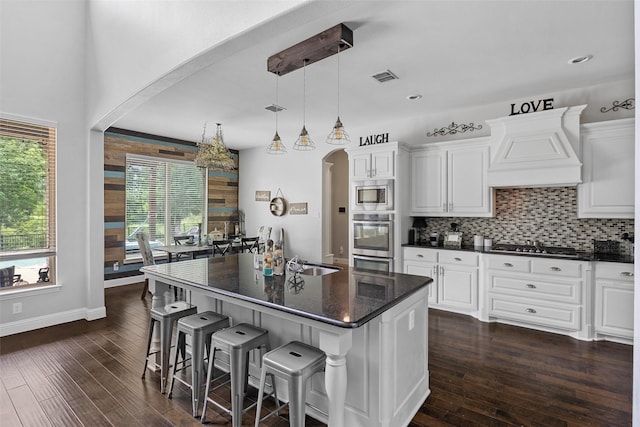 605 Pine Island Cir, Mansfield, TX 76063 - kitchen featuring premium range hood, arched walkways, stainless steel appliances, and dark wood finished floors