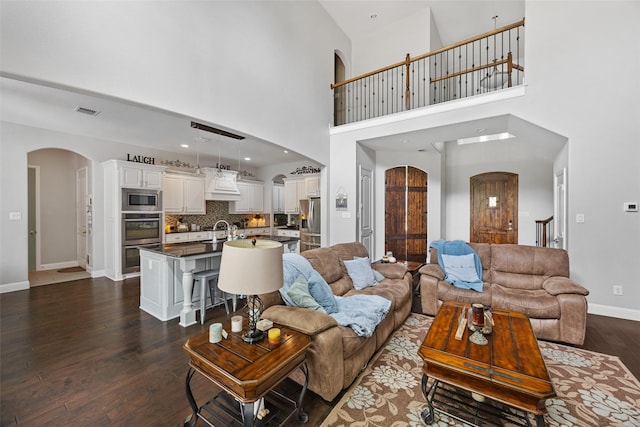 605 Pine Island Cir, Mansfield, TX 76063 - living area with arched walkways, dark wood-style floors, and a towering ceiling