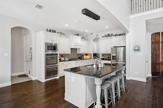 605 Pine Island Cir, Mansfield, TX 76063 - kitchen featuring appliances with stainless steel finishes, dark wood finished floors, backsplash, a breakfast bar, and recessed lighting