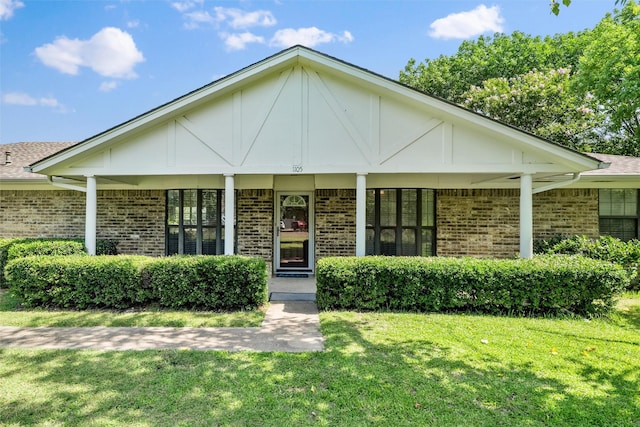 1105 Maree Dr, Waxahachie, TX 75165 - view of front of home with brick siding, a front yard, and covered porch
