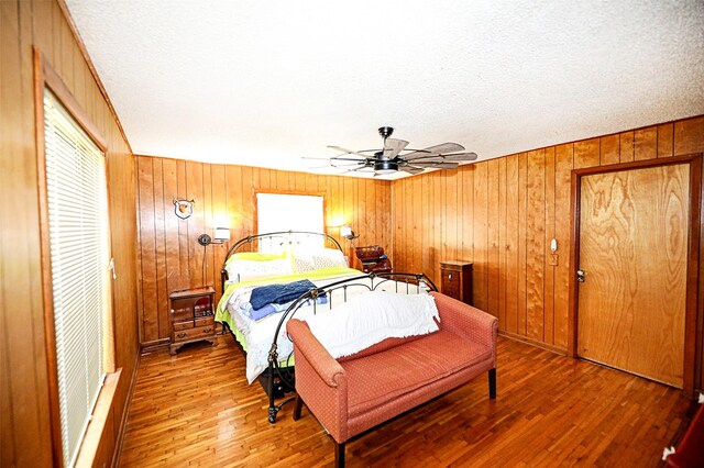 1561 Fm 1816, Bowie, TX 76230 - bedroom with wood finished floors, wood walls, and ceiling fan