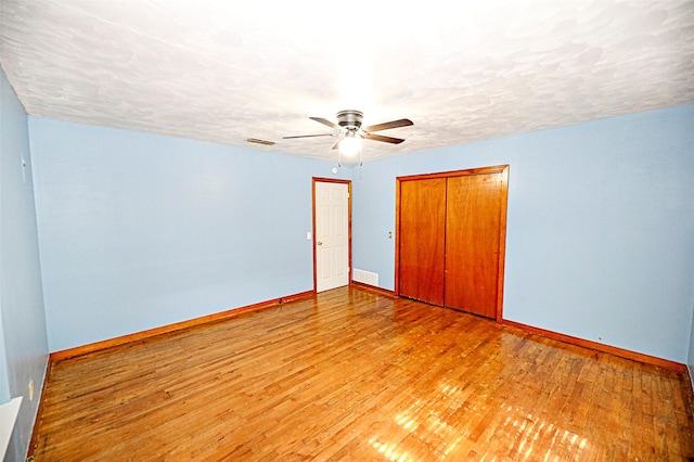 1561 Fm 1816, Bowie, TX 76230 - unfurnished bedroom with a closet, wood finished floors, ceiling fan, and a textured ceiling