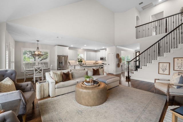 750 Camden Way, Prosper, TX 75078 - living area featuring dark wood-style flooring, a chandelier, stairway, plenty of natural light, and a towering ceiling