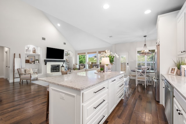 750 Camden Way, Prosper, TX 75078 - kitchen with dark wood-style floors, a glass covered fireplace, a center island, appliances with stainless steel finishes, and recessed lighting