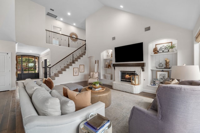 750 Camden Way, Prosper, TX 75078 - living room featuring high vaulted ceiling, wood finished floors, stairs, built in shelves, and a brick fireplace