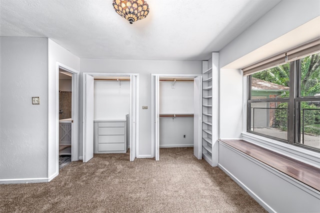 5912 Whitman Ave, Fort Worth, TX 76133 - unfurnished bedroom with multiple closets, carpet flooring, and a textured ceiling