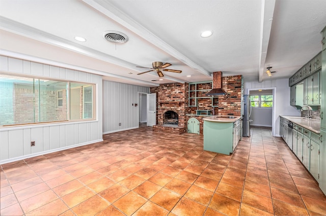 5912 Whitman Ave, Fort Worth, TX 76133 - kitchen with green cabinets, freestanding refrigerator, a brick fireplace, wall chimney range hood, and ceiling fan