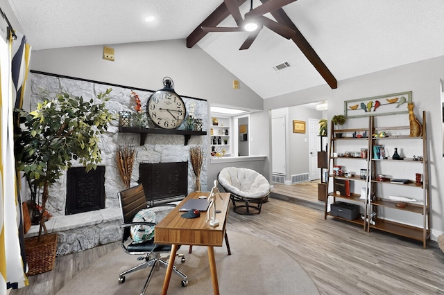 5700 Kingstree Ct, Arlington, TX 76017 - living area featuring a stone fireplace, a ceiling fan, wood finished floors, beamed ceiling, and high vaulted ceiling