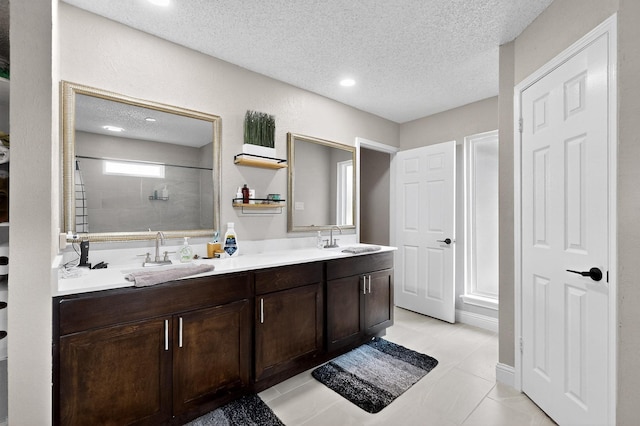 5700 Kingstree Ct, Arlington, TX 76017 - bathroom featuring double vanity, tiled shower, a textured ceiling, tile patterned floors, and recessed lighting