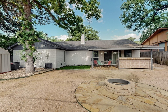 5700 Kingstree Ct, Arlington, TX 76017 - back of property with a fire pit, a patio, brick siding, a chimney, and roof with shingles