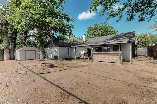 5700 Kingstree Ct, Arlington, TX 76017 - rear view of property featuring an outdoor fire pit, brick siding, a storage shed, a chimney, and a patio
