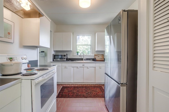 4711 Birchman Ave, Fort Worth, TX 76107 - kitchen with stainless steel appliances, white cabinets, exhaust hood, and tile patterned floors