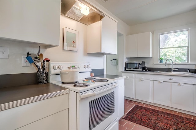 4711 Birchman Ave, Fort Worth, TX 76107 - kitchen featuring white range with electric cooktop, stainless steel microwave, white cabinetry, and wall chimney range hood