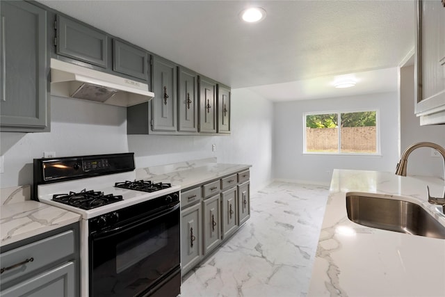 1007 Elk Grove Dr, Richardson, TX 75081 - kitchen featuring range with gas cooktop, under cabinet range hood, light marble finish flooring, gray cabinets, and light stone countertops