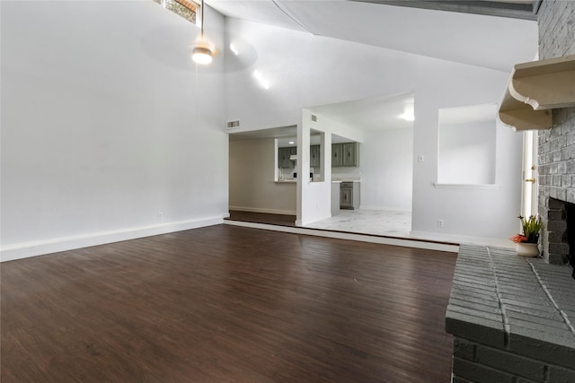 1007 Elk Grove Dr, Richardson, TX 75081 - unfurnished living room with a brick fireplace, wood finished floors, and high vaulted ceiling