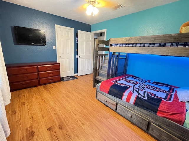 101 Branch St, Pittsburg, TX 75686 - bedroom with a textured wall, wood finished floors, ceiling fan, and a textured ceiling