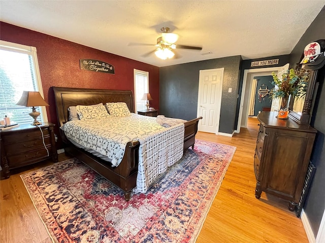 101 Branch St, Pittsburg, TX 75686 - bedroom with multiple windows, light wood finished floors, a textured ceiling, and a ceiling fan
