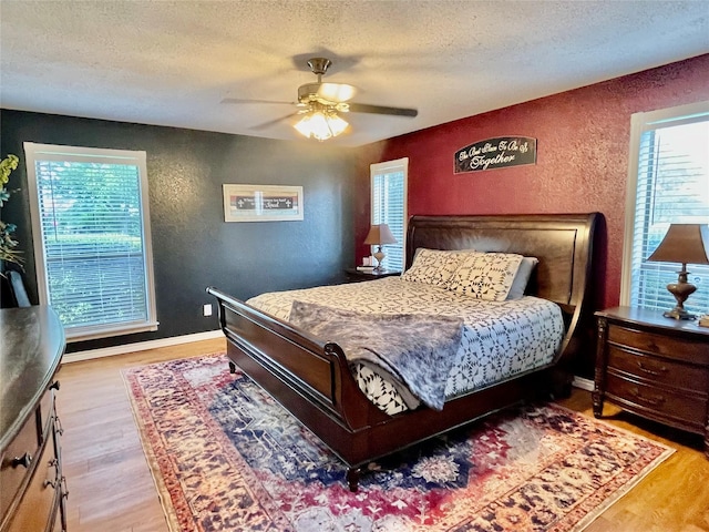101 Branch St, Pittsburg, TX 75686 - bedroom featuring a textured wall, a textured ceiling, wood finished floors, multiple windows, and ceiling fan