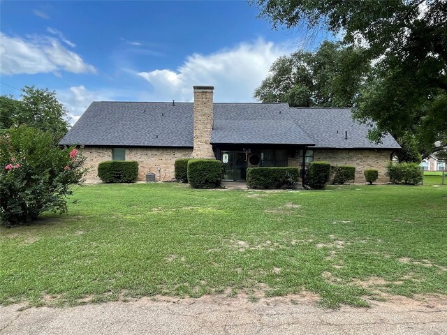 101 Branch St, Pittsburg, TX 75686 - back of house featuring a chimney, a yard, roof with shingles, and brick siding