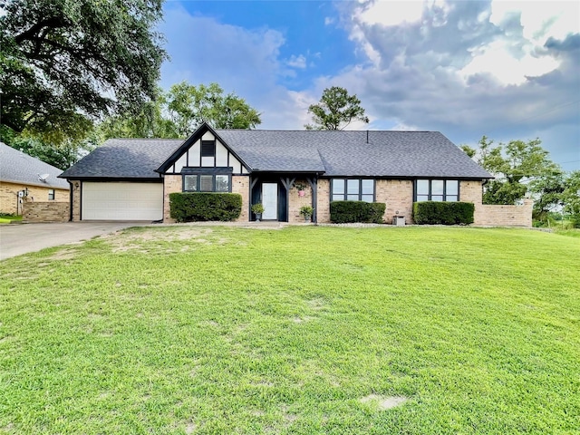 101 Branch St, Pittsburg, TX 75686 - tudor home featuring driveway, a garage, a front lawn, and roof with shingles