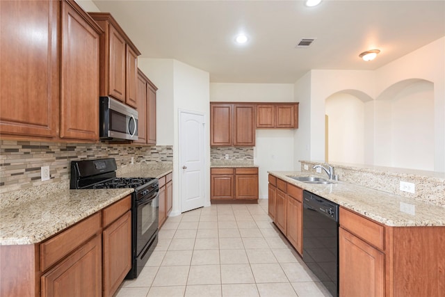 211 Wooded Creek Ave, Wylie, TX 75098 - kitchen featuring black appliances, brown cabinets, tasteful backsplash, light tile patterned floors, and light stone counters