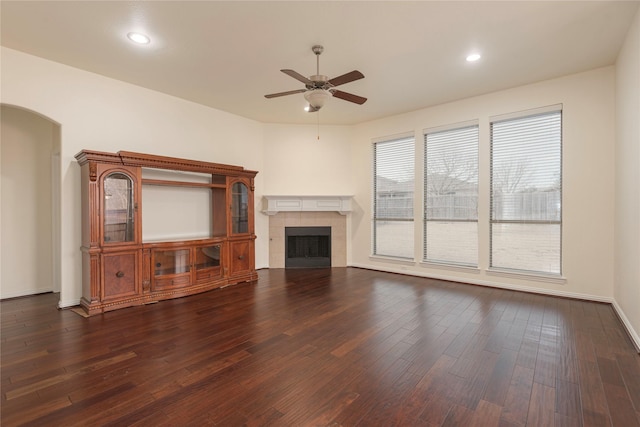 211 Wooded Creek Ave, Wylie, TX 75098 - unfurnished living room featuring a ceiling fan, arched walkways, dark wood finished floors, a fireplace, and recessed lighting