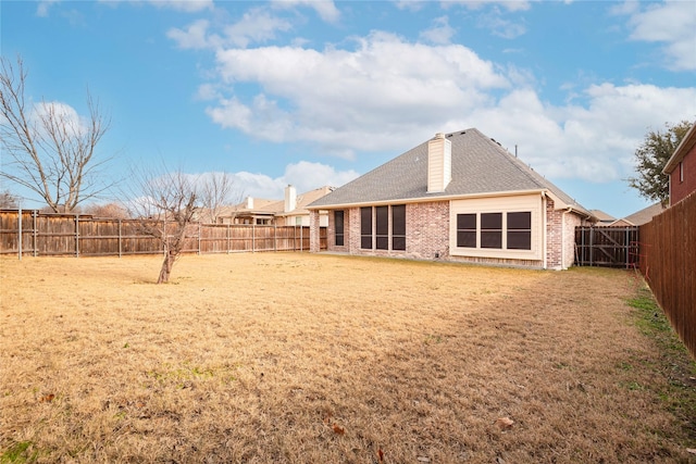 211 Wooded Creek Ave, Wylie, TX 75098 - back of house featuring a fenced backyard, brick siding, a chimney, and roof with shingles